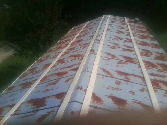 Rusted metal roof panels with new wood purlins before replacement — Storm Damage Roof Repair in Abita Springs by Roofing Brothers