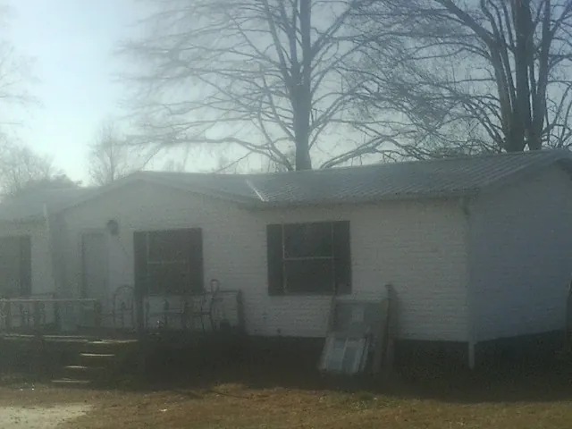 New metal roof on a white painted brick home on a foggy morning in Abita Springs