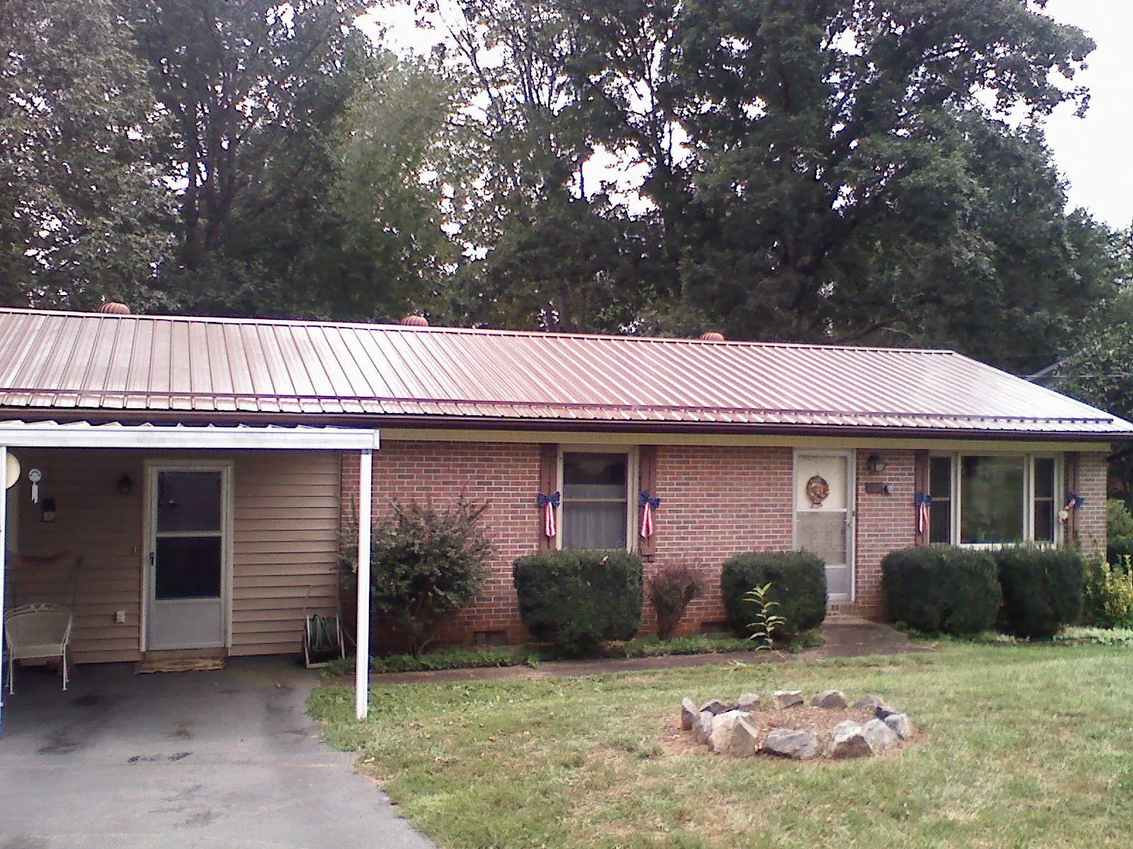 Bronze metal roof and carport on a brick ranch home — Roof Repair work by our crew in Abita Springs