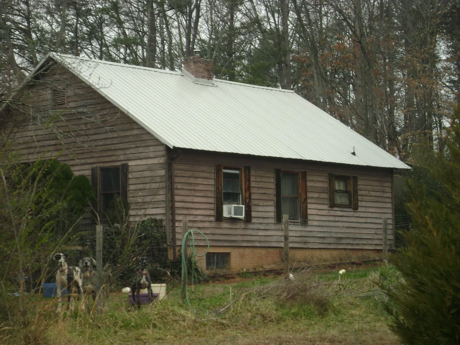White metal roof on an old wood sided farmhouse, from a Metal Roof Installation job in Abita Springs